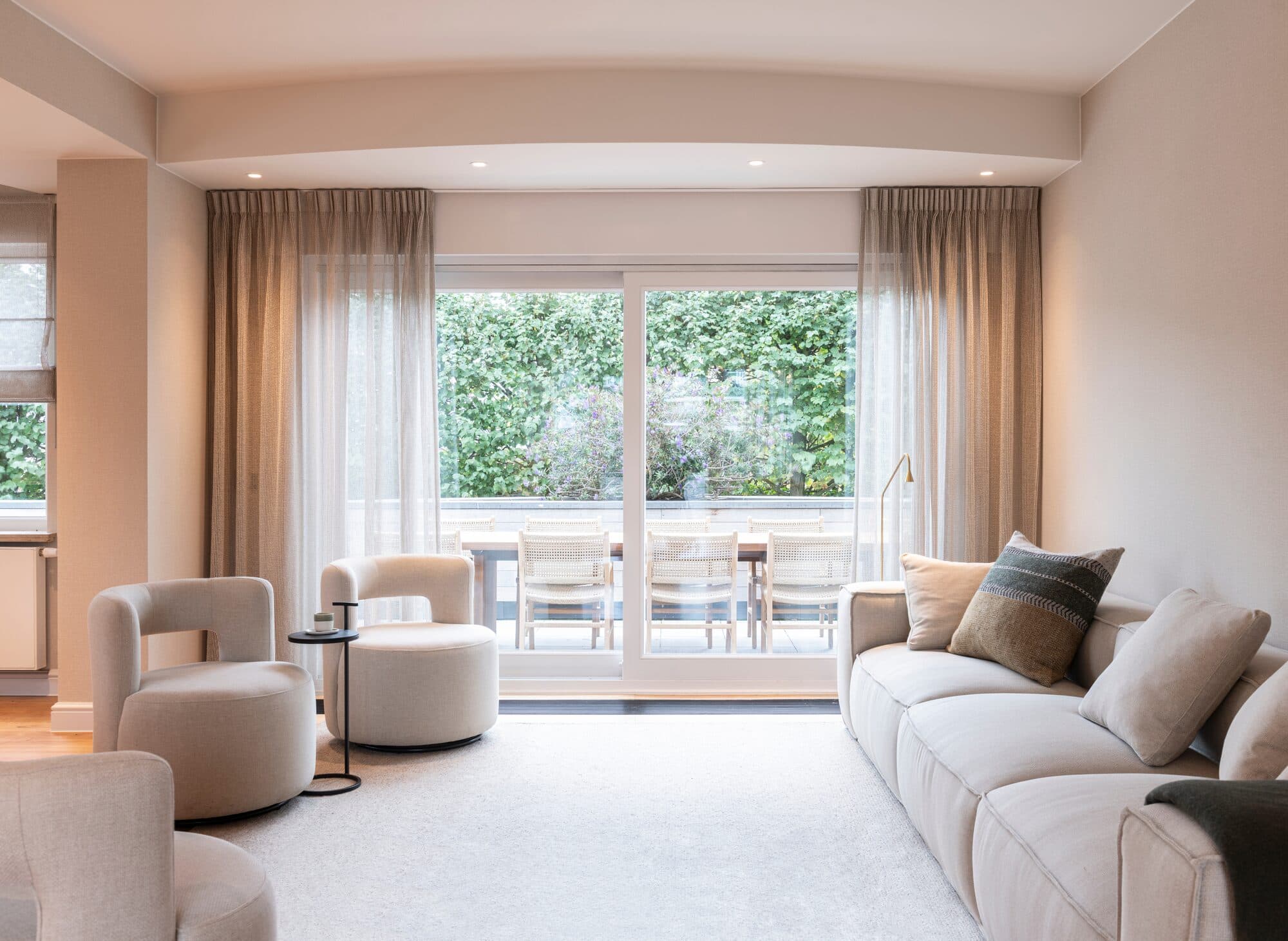 Lichte zithoek met openslaande deuren naar de tuin van een villa in Knokke