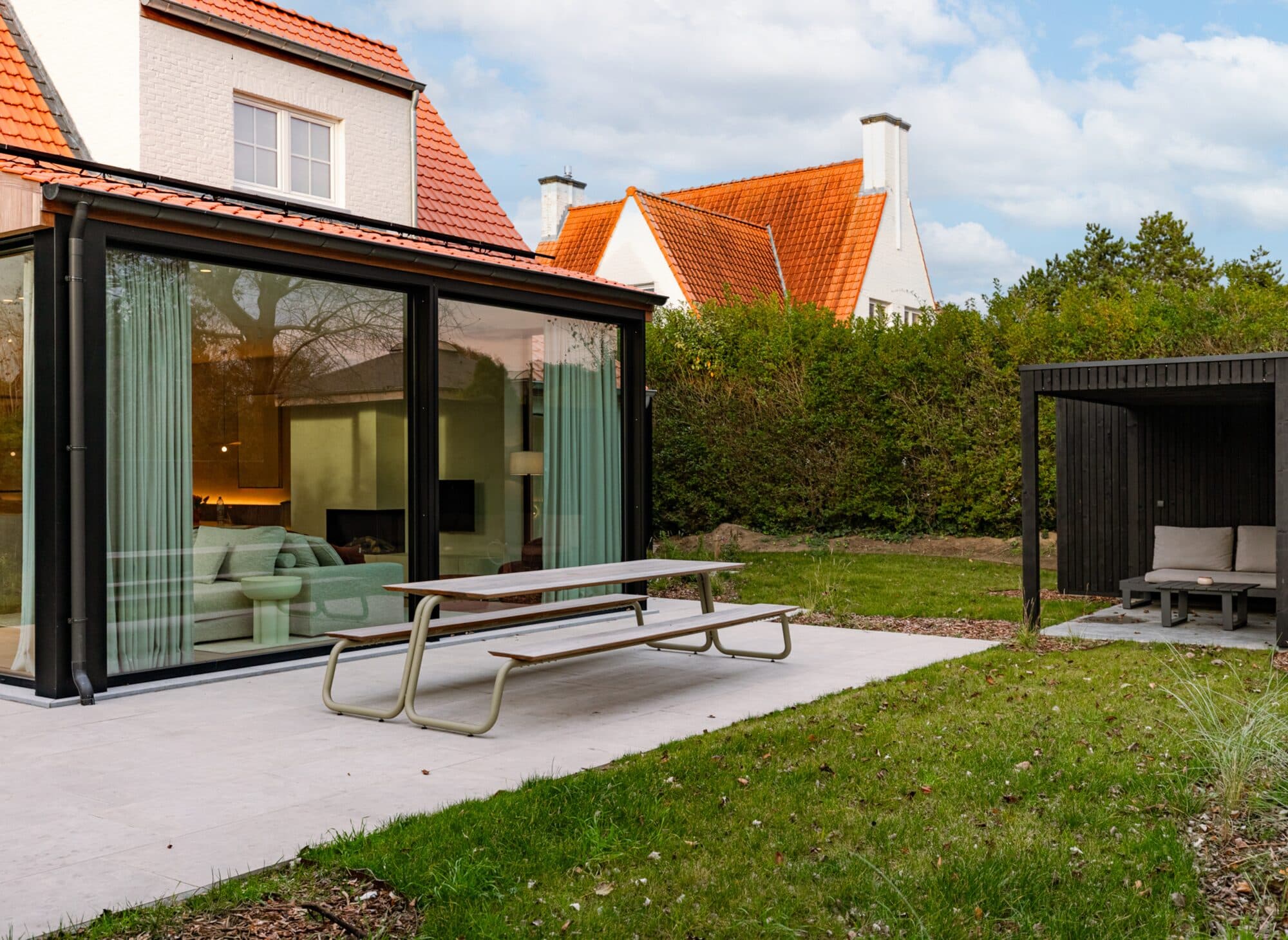 Tuin met veranda en terras bij een woning in Knokke